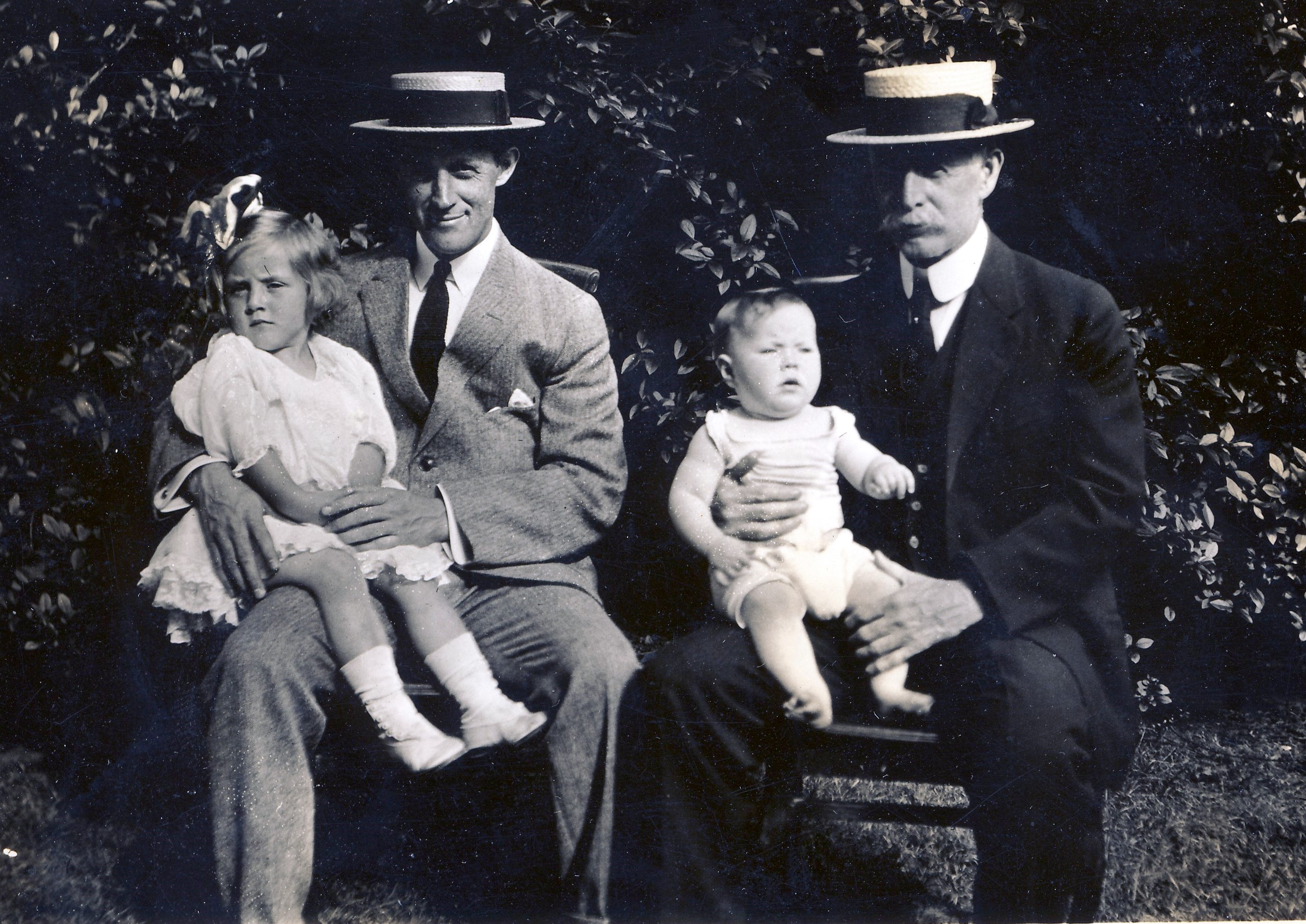 1913 Jean Gordon and Tom Hart sitting on the laps of Charles and Cornelius Hart